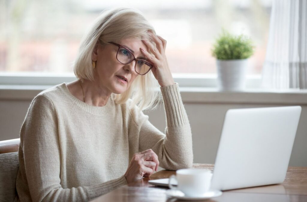 An older adult woman with a look of confusion trying to figure out what is displayed on her laptop