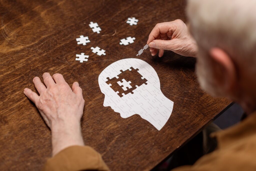 An older adult finishing a jigsaw puzzle symbolizing memory decline.
