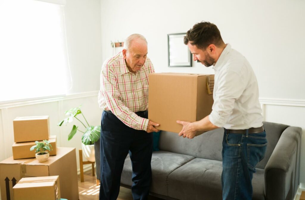 a young man helps his elderly father move a bpx