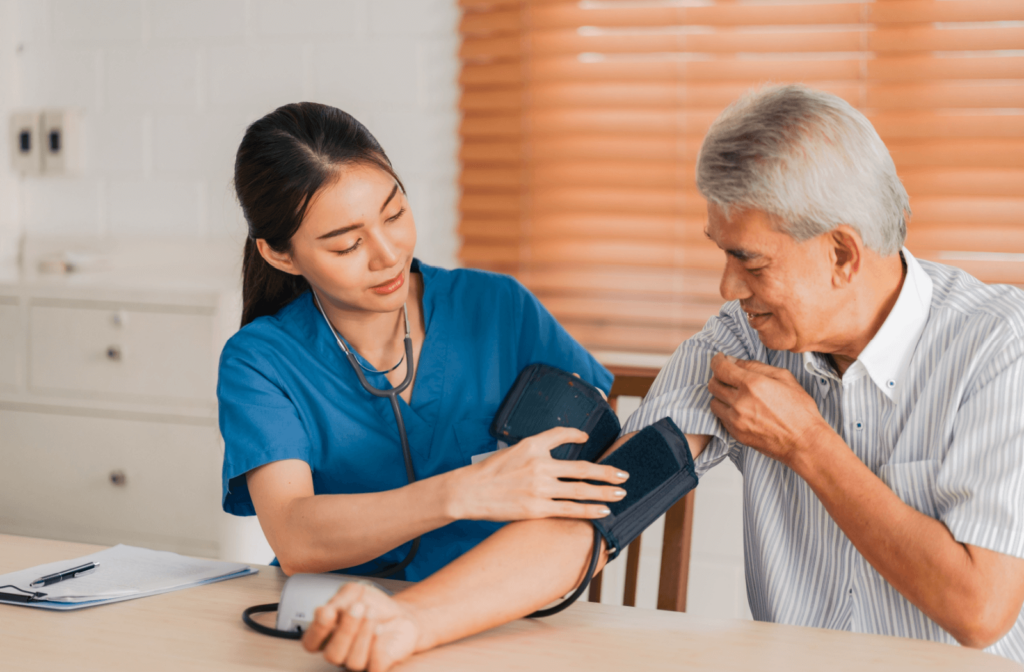 A nurse checks a senior resident's blood pressure in a memory care community.